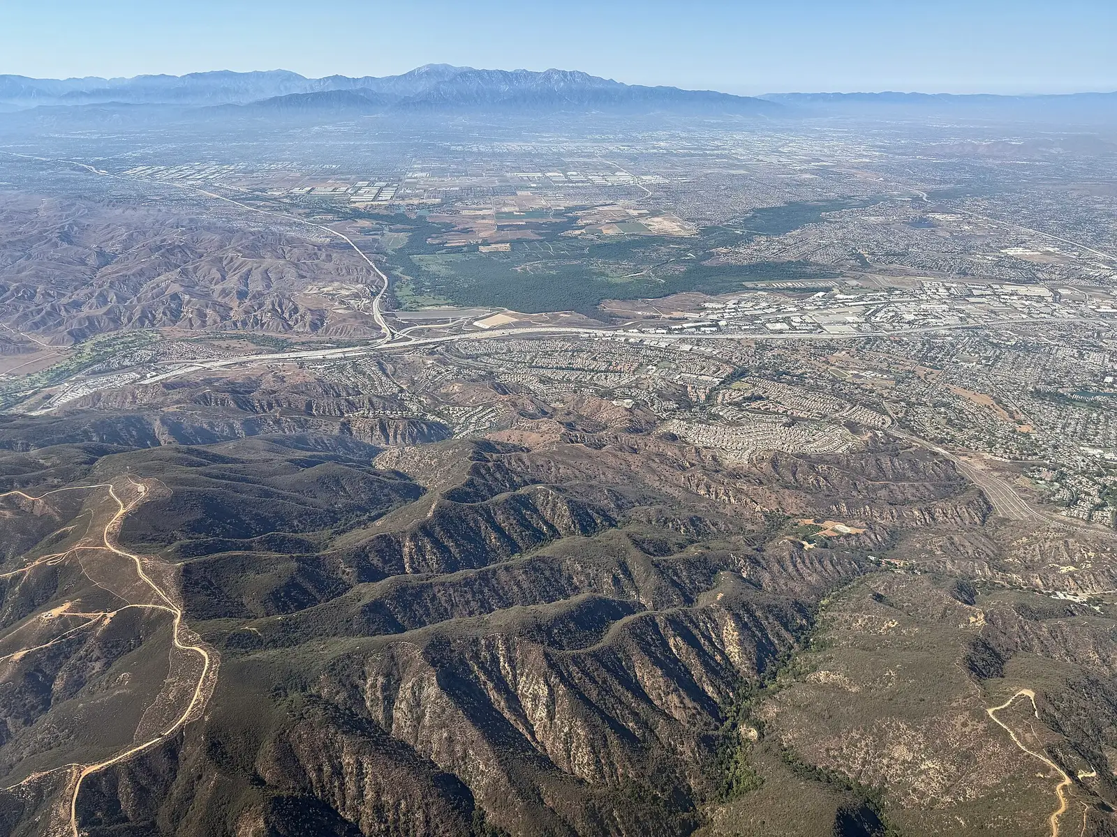 Aerial view of Corona, California, with residential neighborhoods extending toward the Santa Ana Mountains